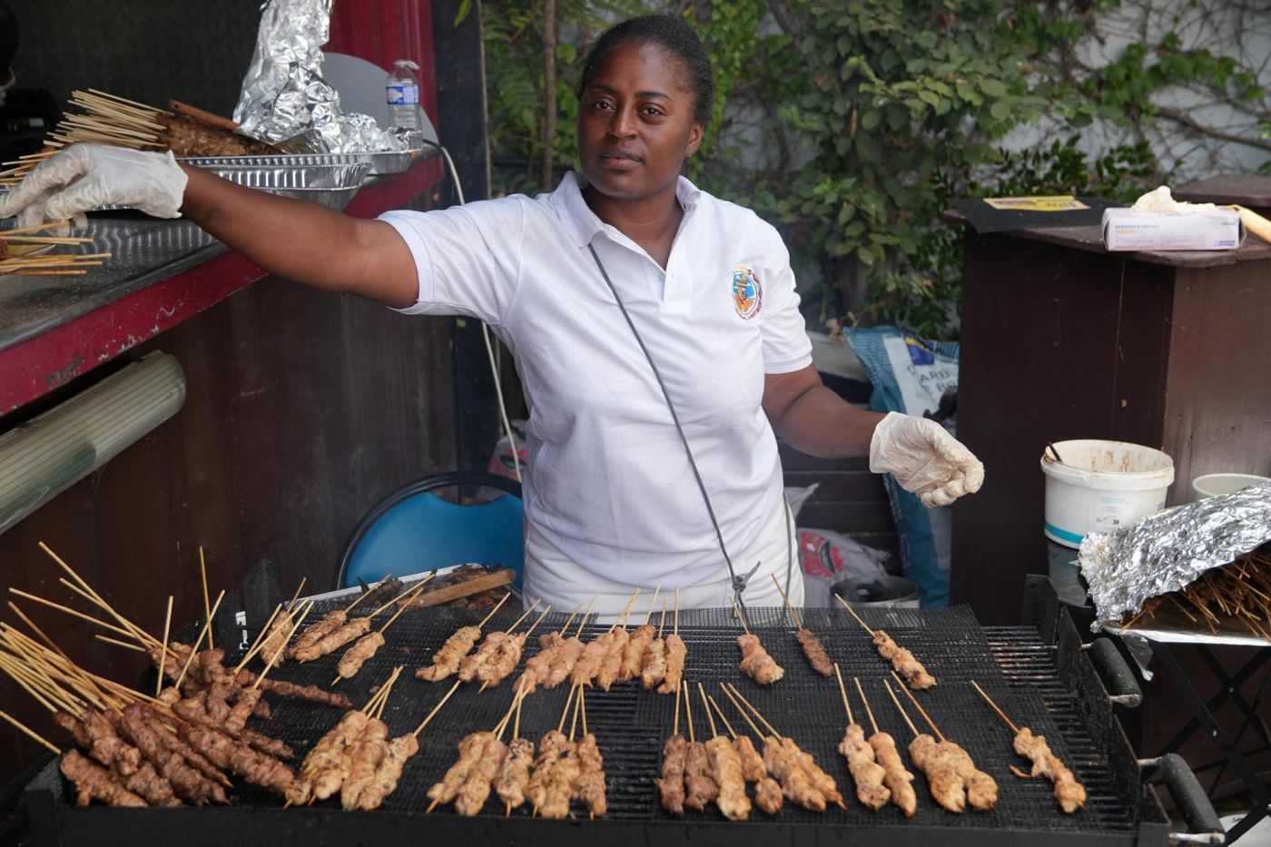 Cuisinière devant un grand barbecue de brochettes